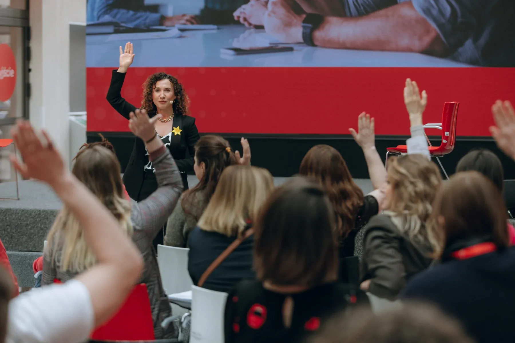 Magdalena Petryniak inviting active participation from an audience with raised hands