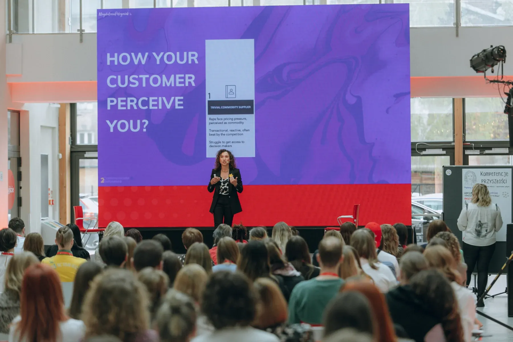 Magdalena Petryniak delivering a keynote about customer perception to a large audience