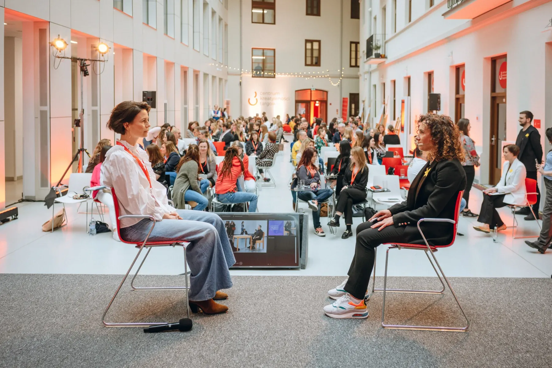 Magdalena Petryniak and a participant taking part in an eye-gazing exercise on stage